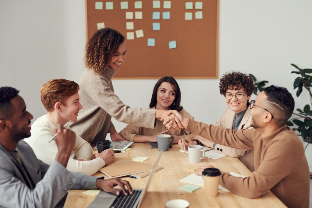 People at work shaking hands after resolving a conflict