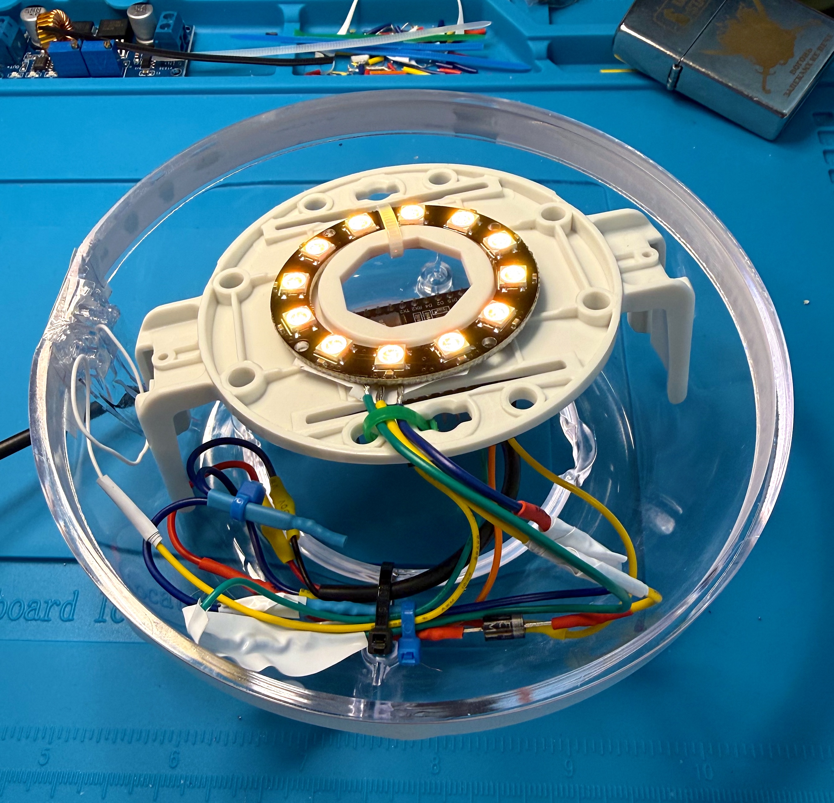 The WS2812 ring lit warm white, mounted on the base plate inside the lower egg half