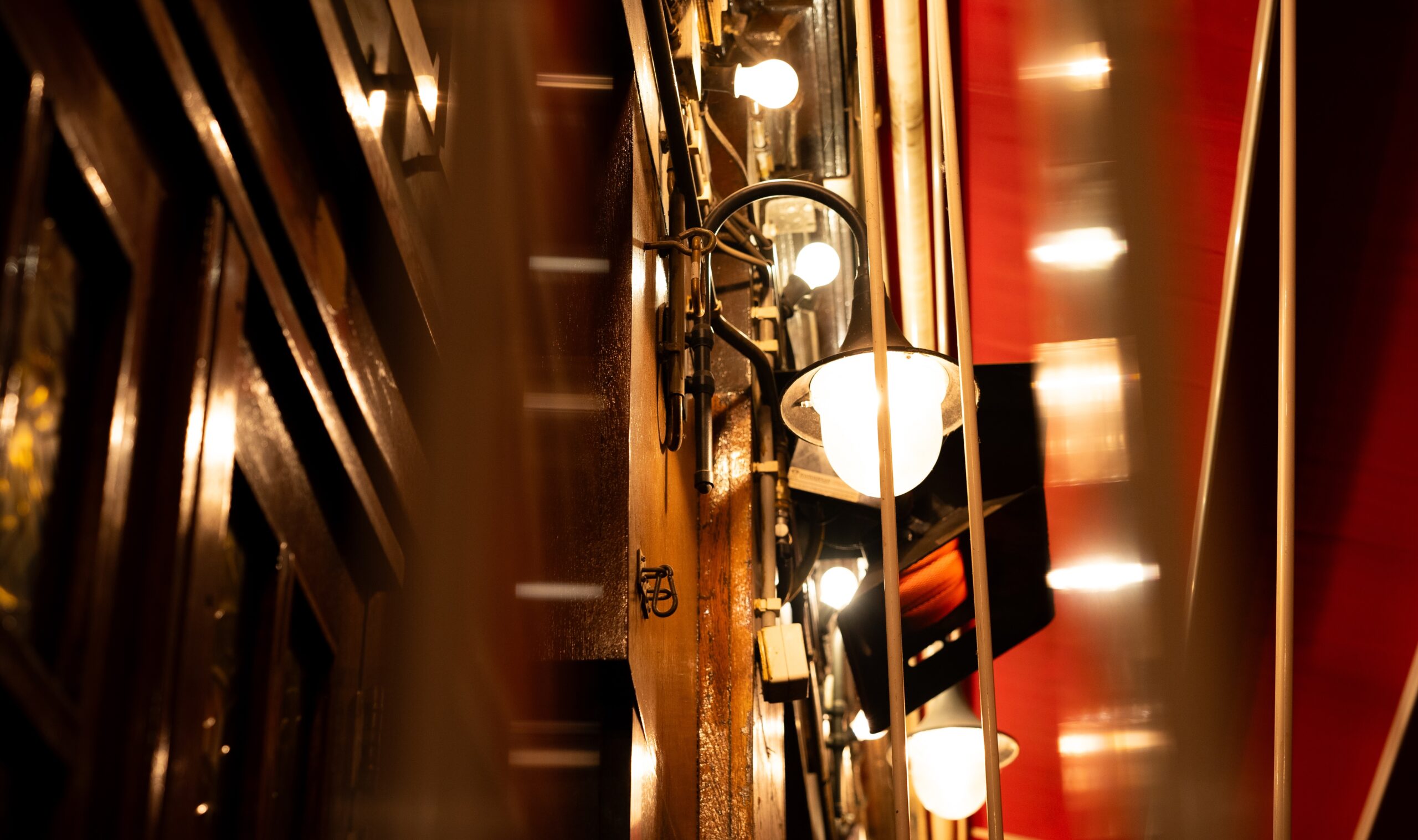 Bright lamps on a wall in a brown pub